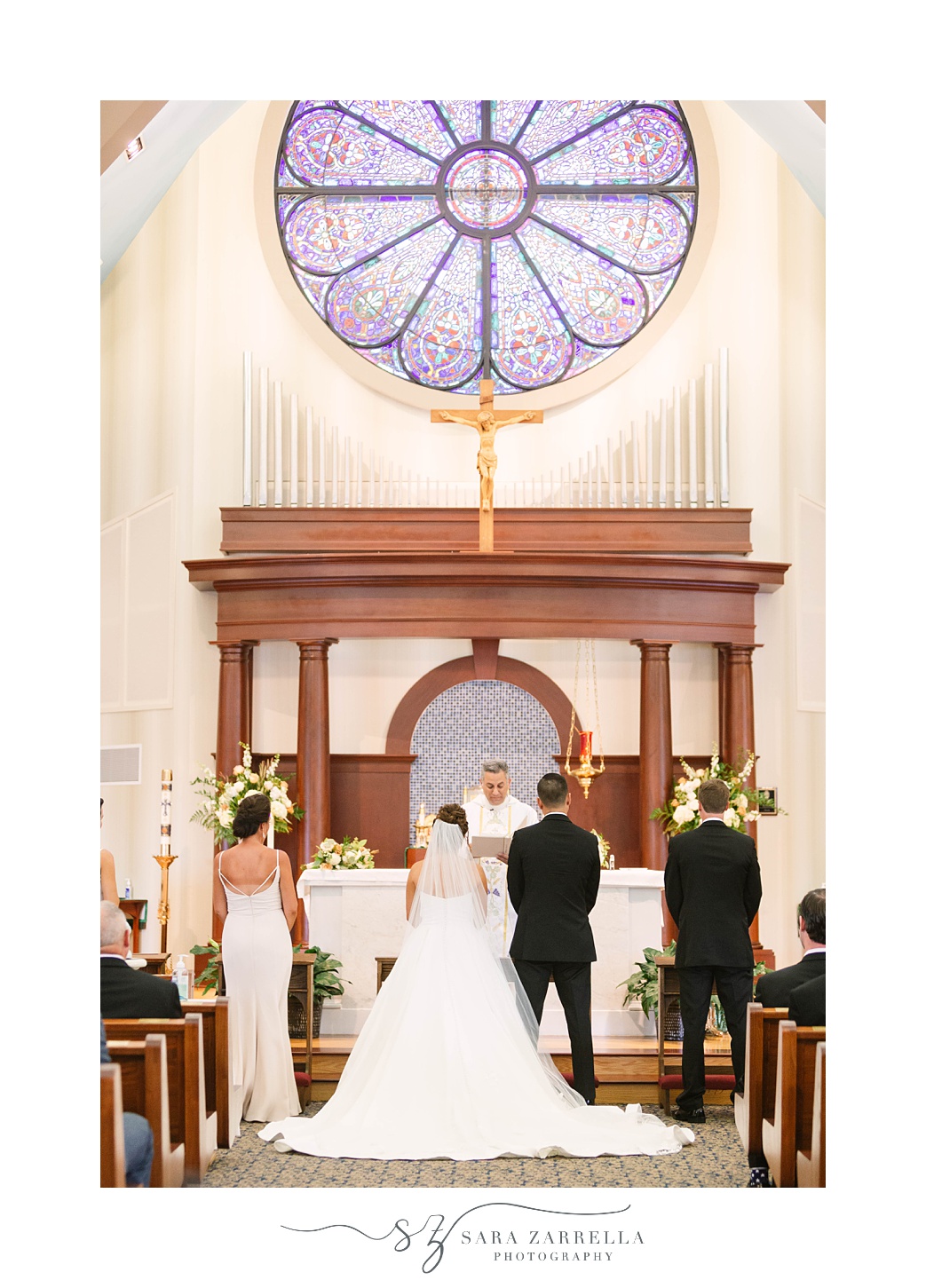 newlyweds sit listening during traditional church wedding in Massachusetts