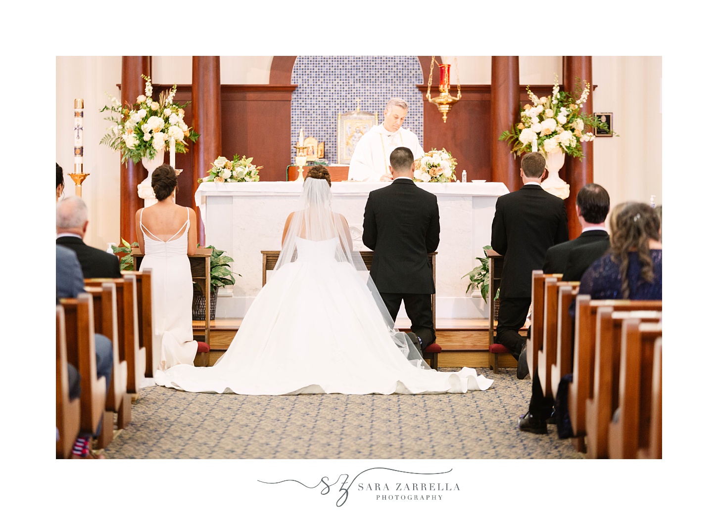 newlyweds kneel during traditional church wedding in Massachusetts