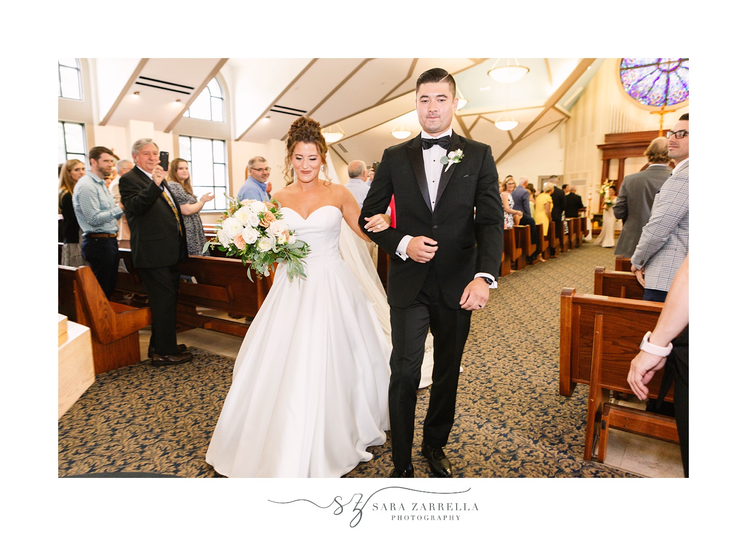 bride and groom walk up aisle after traditional church wedding in Massachusetts
