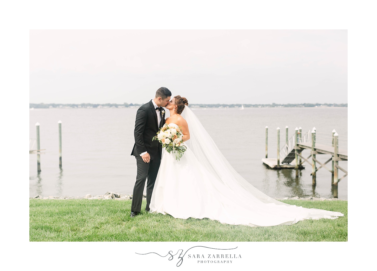 newlyweds kiss by water at Lakeview Pavilion