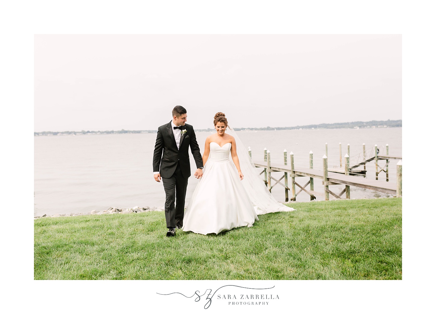 newlyweds walk along waterfront at Lakeview Pavilion