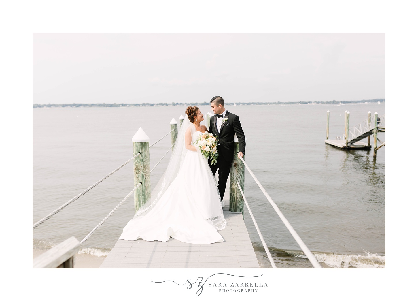 bride and groom stand on dock in Foxboro MA on wedding day
