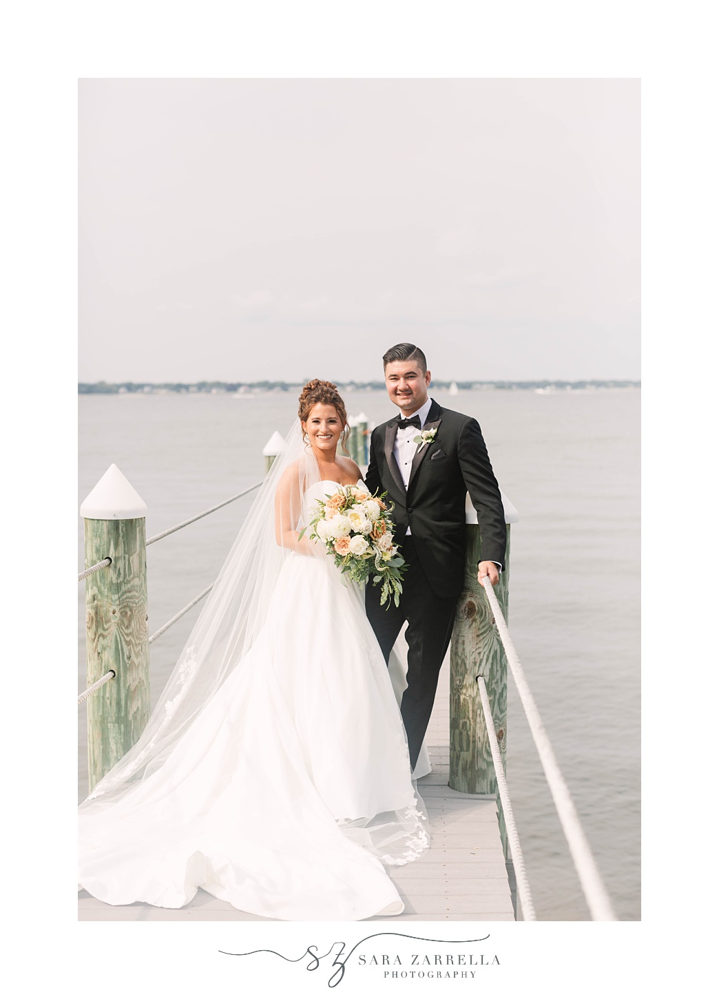 newlyweds pose on dock at Lakeview Pavilion
