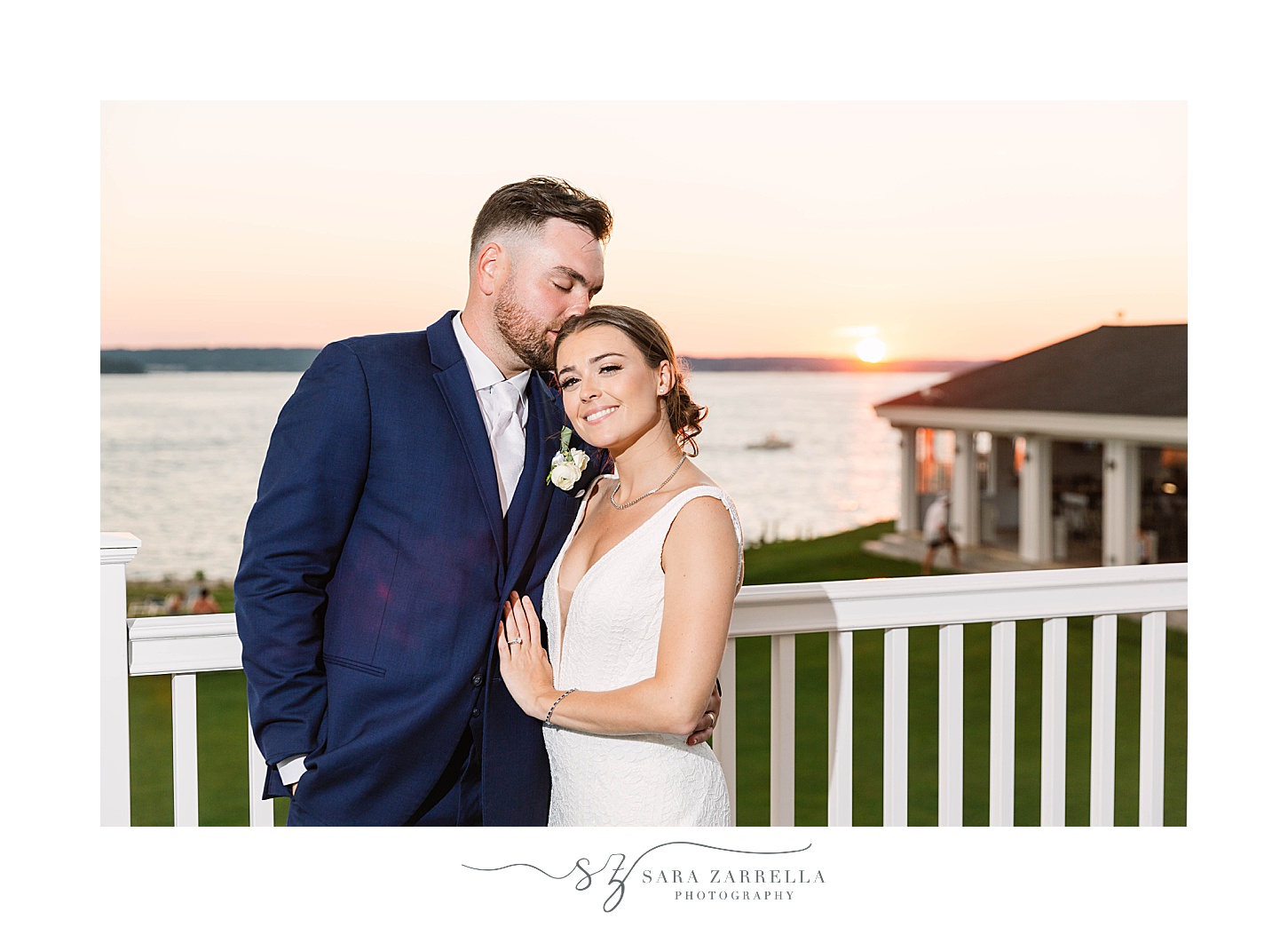 bride and groom stand on balcony at Warwick Country Club at sunset