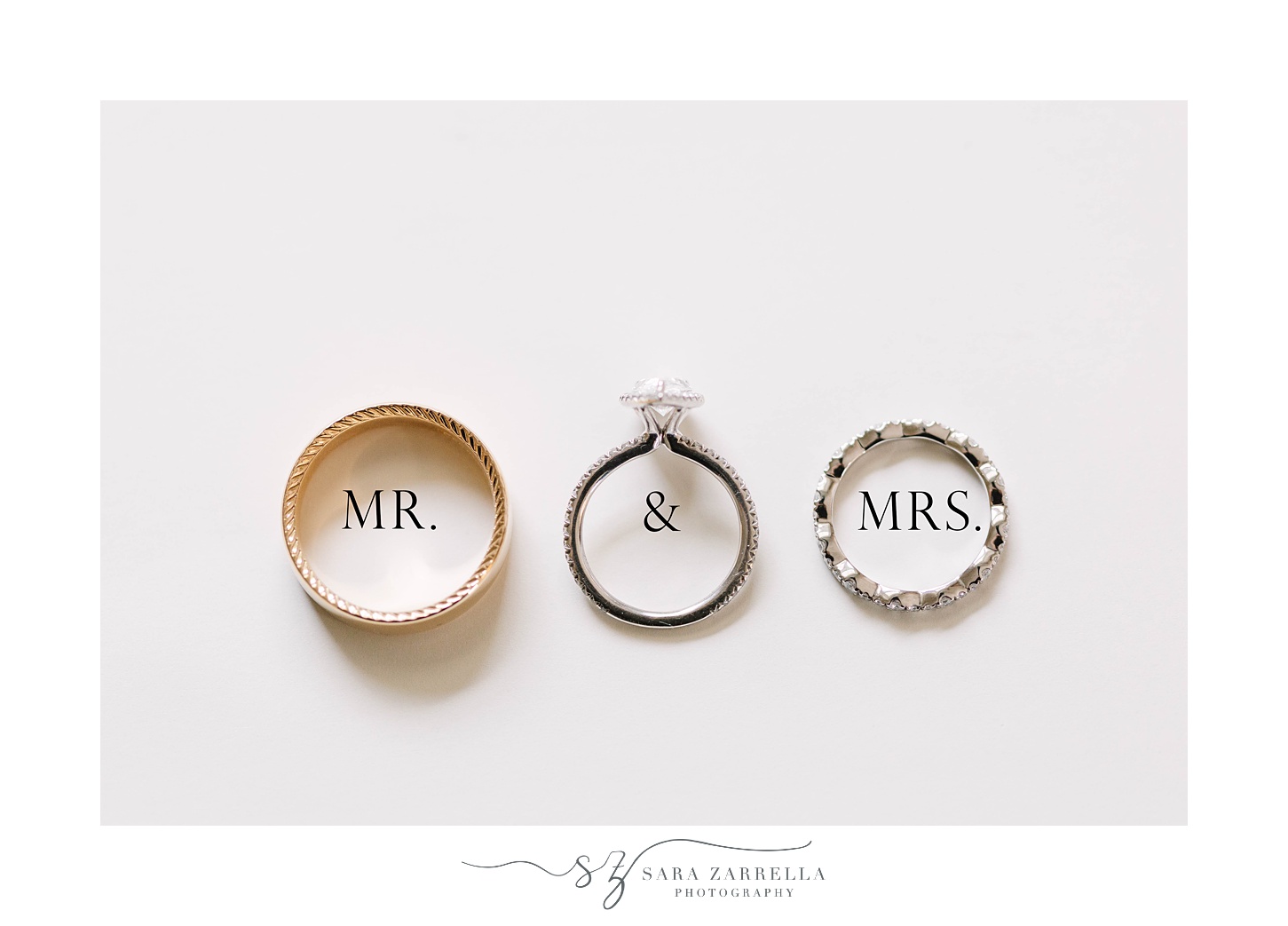 wedding bands lay over Mr. and Mrs. words