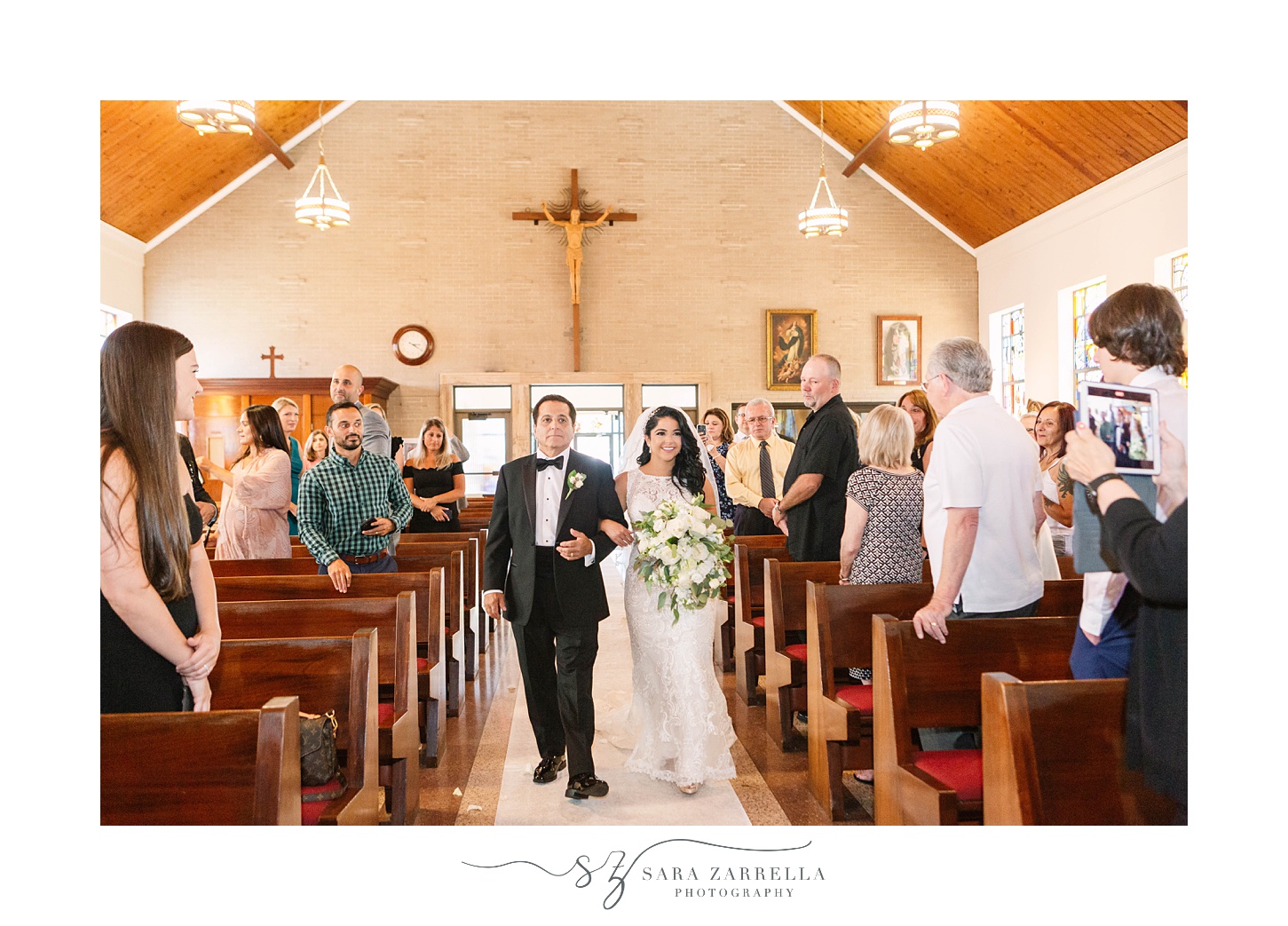bride walks down aisle with father for traditional church wedding in Rhode Island