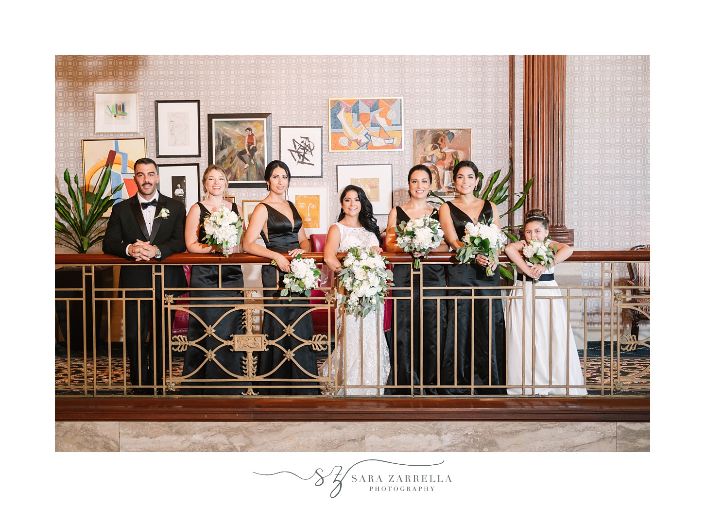 bride and wedding party look over balcony at  Quidnessett Country Club