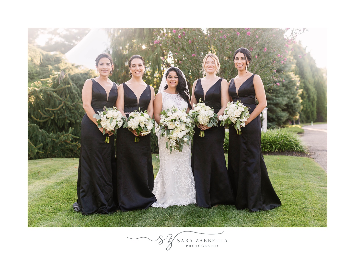 bride poses with bridesmaids in black satin gowns
