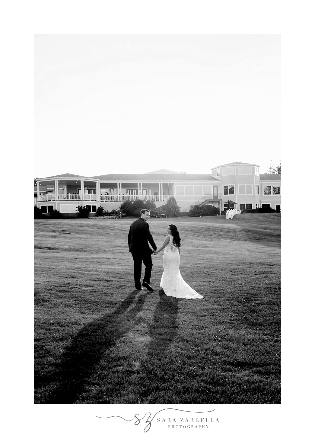 bride and groom hold hands walking through the lawn at  Quidnessett Country Club