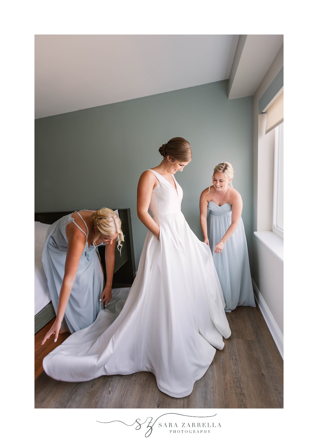 bridesmaids help bride with gown during Atlantic Resort at Wyndham Newport wedding day prep
