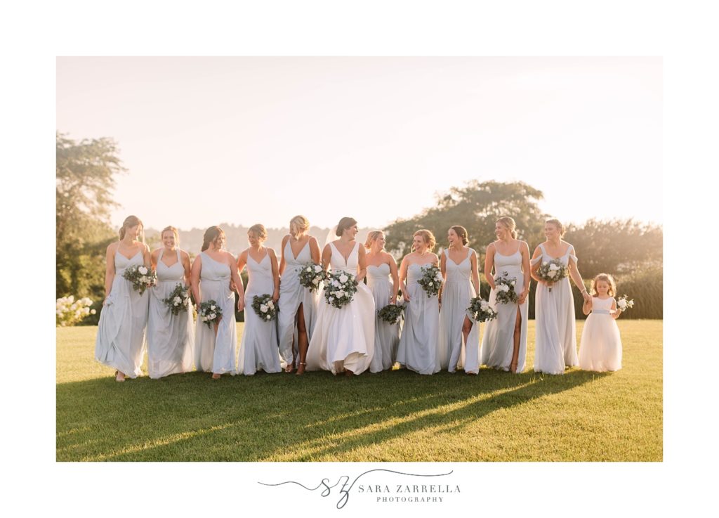 bride walks with bridesmaids in blue gowns
