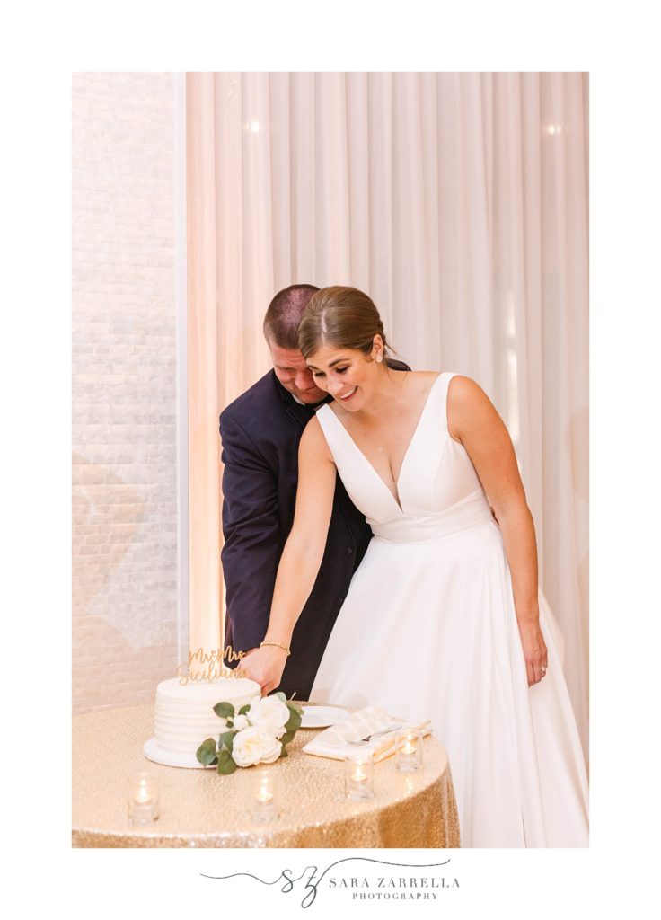 newlyweds cut wedding cake together in Newport RI