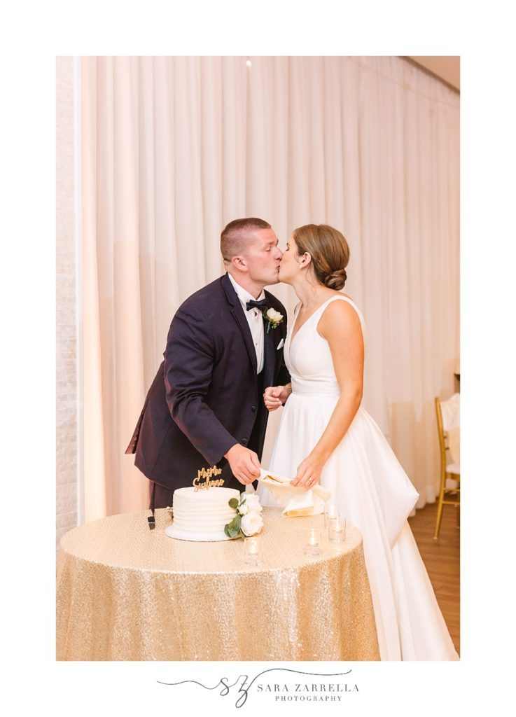 bride and groom kiss during cake cutting at Atlantic Resort at Wyndham Newport