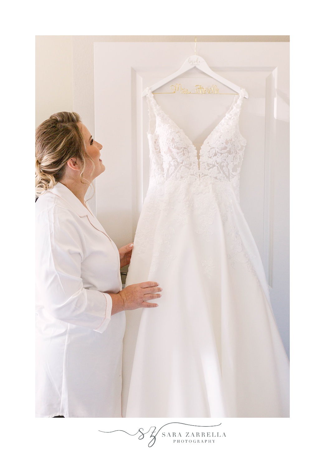 bride looks up at wedding gown before Quidnessett Country Club wedding