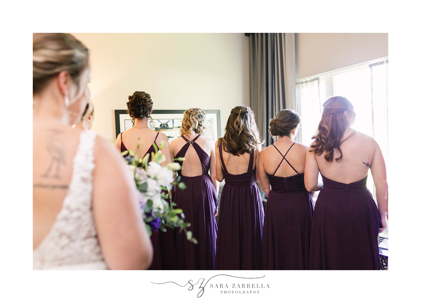 bride has first look with bridesmaids in purple gowns