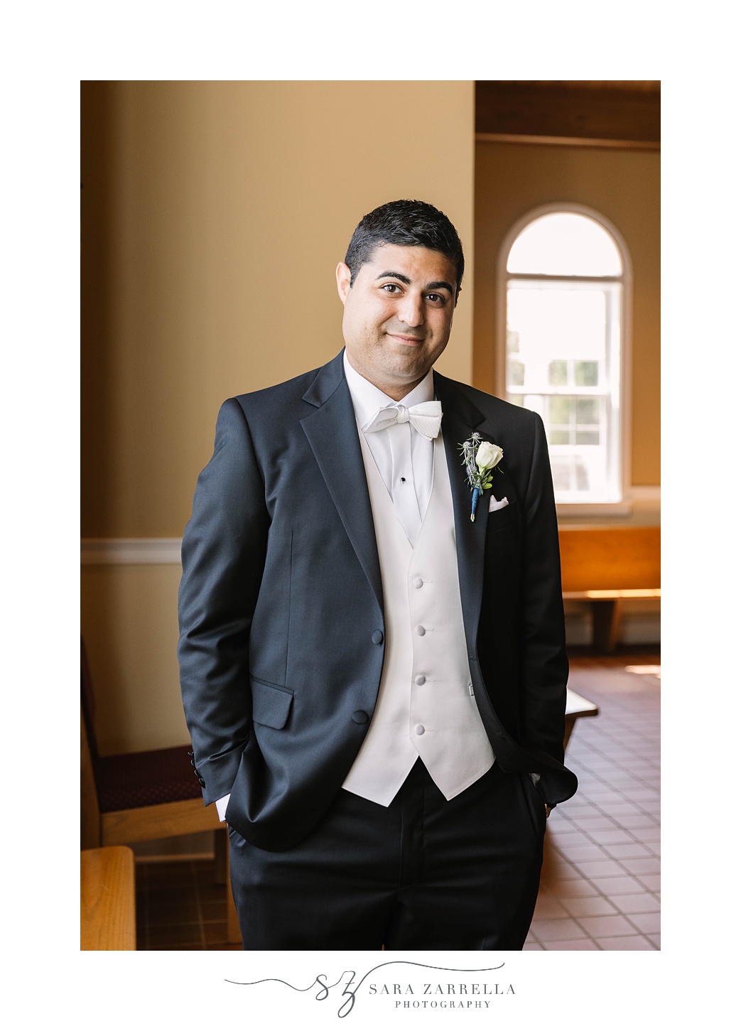 groom stands in pews at church