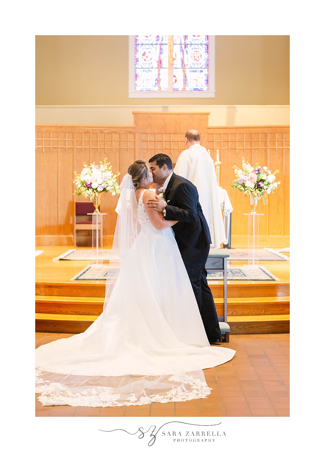 bride and groom kiss during traditional wedding ceremony in Rhode Island church
