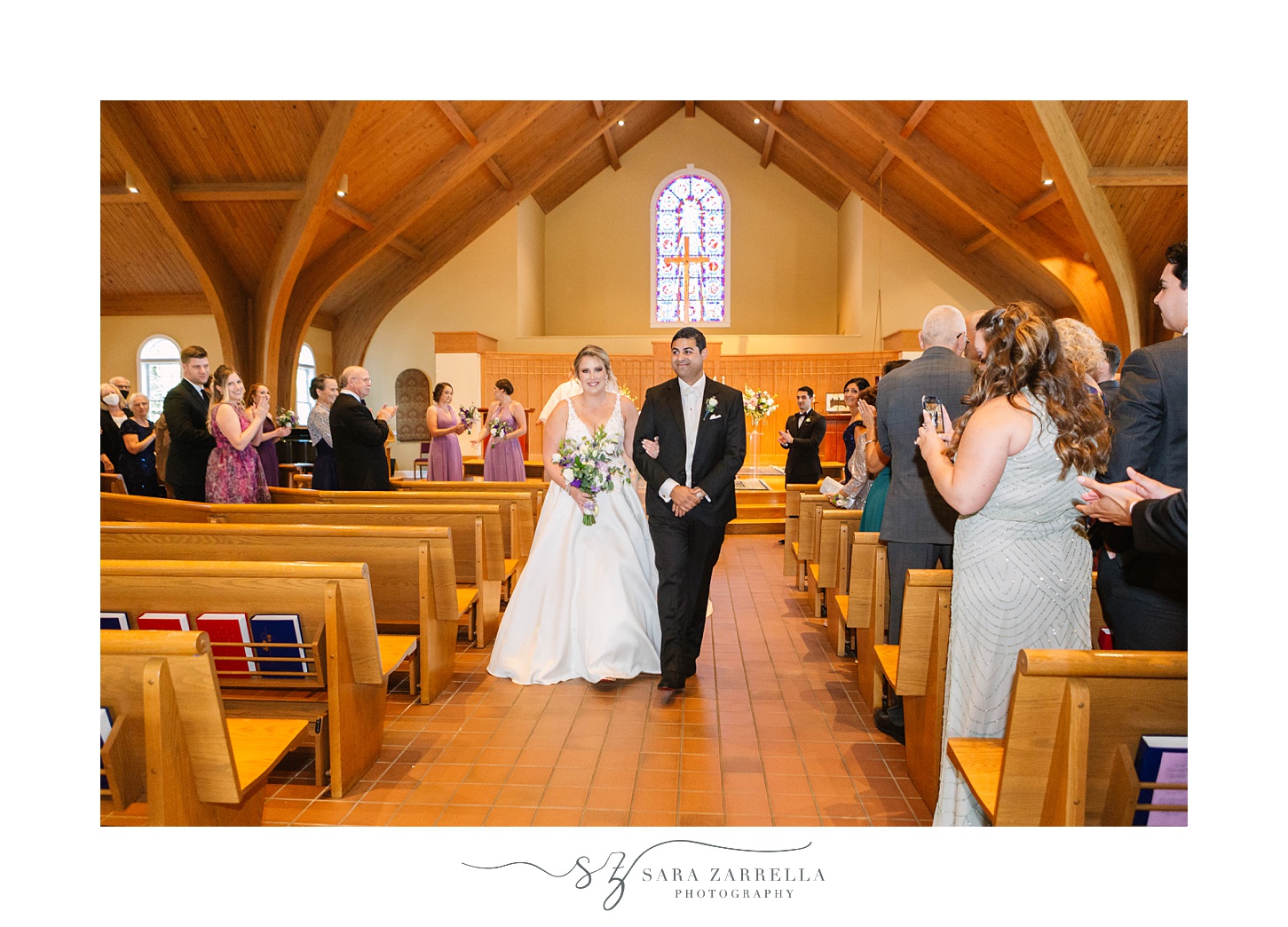 bride and groom recess up aisle after traditional wedding ceremony in Rhode Island church