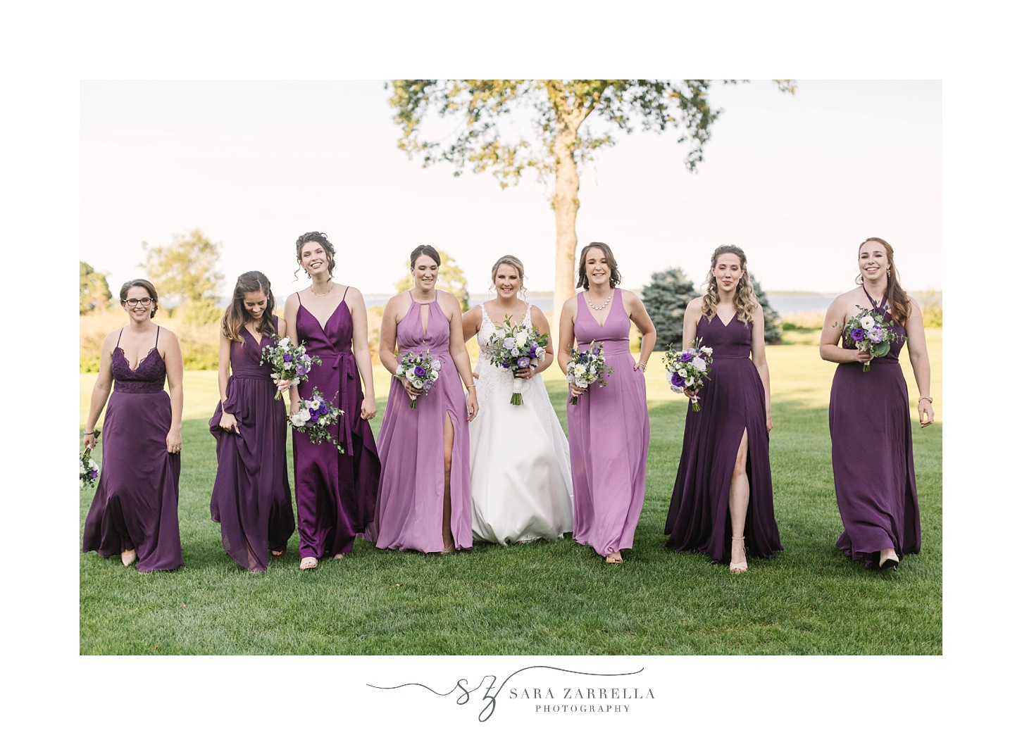 bride and bridesmaids in purple gowns walk outside the Quidnessett Country Club