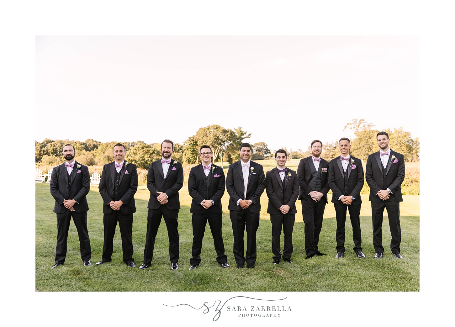 groom and groomsmen stand together outside Quidnessett Country Club in Rhode Island