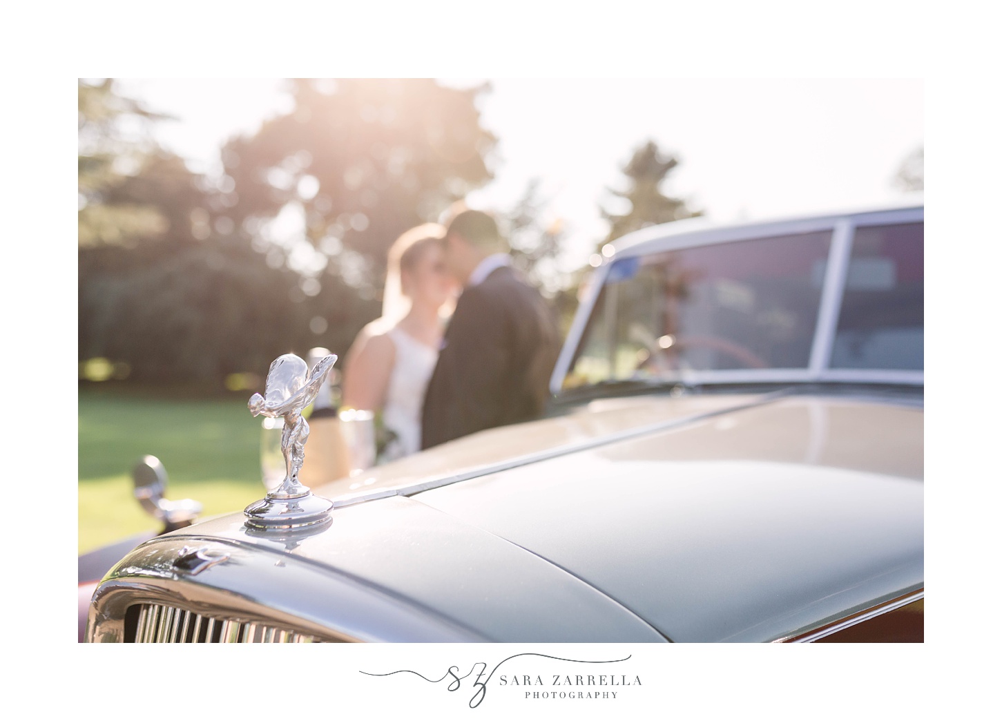 bride and groom kiss next to classic car