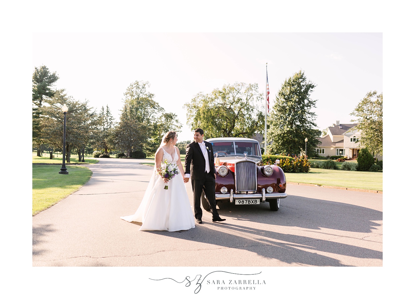 newlyweds walk by classic cart at Quidnessett Country Club