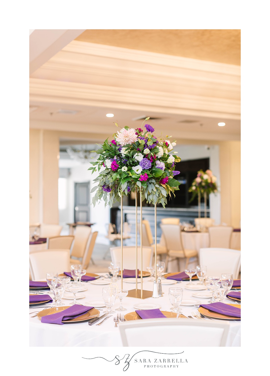 tall floral centerpieces with gold and purple accents at Quidnessett Country Club