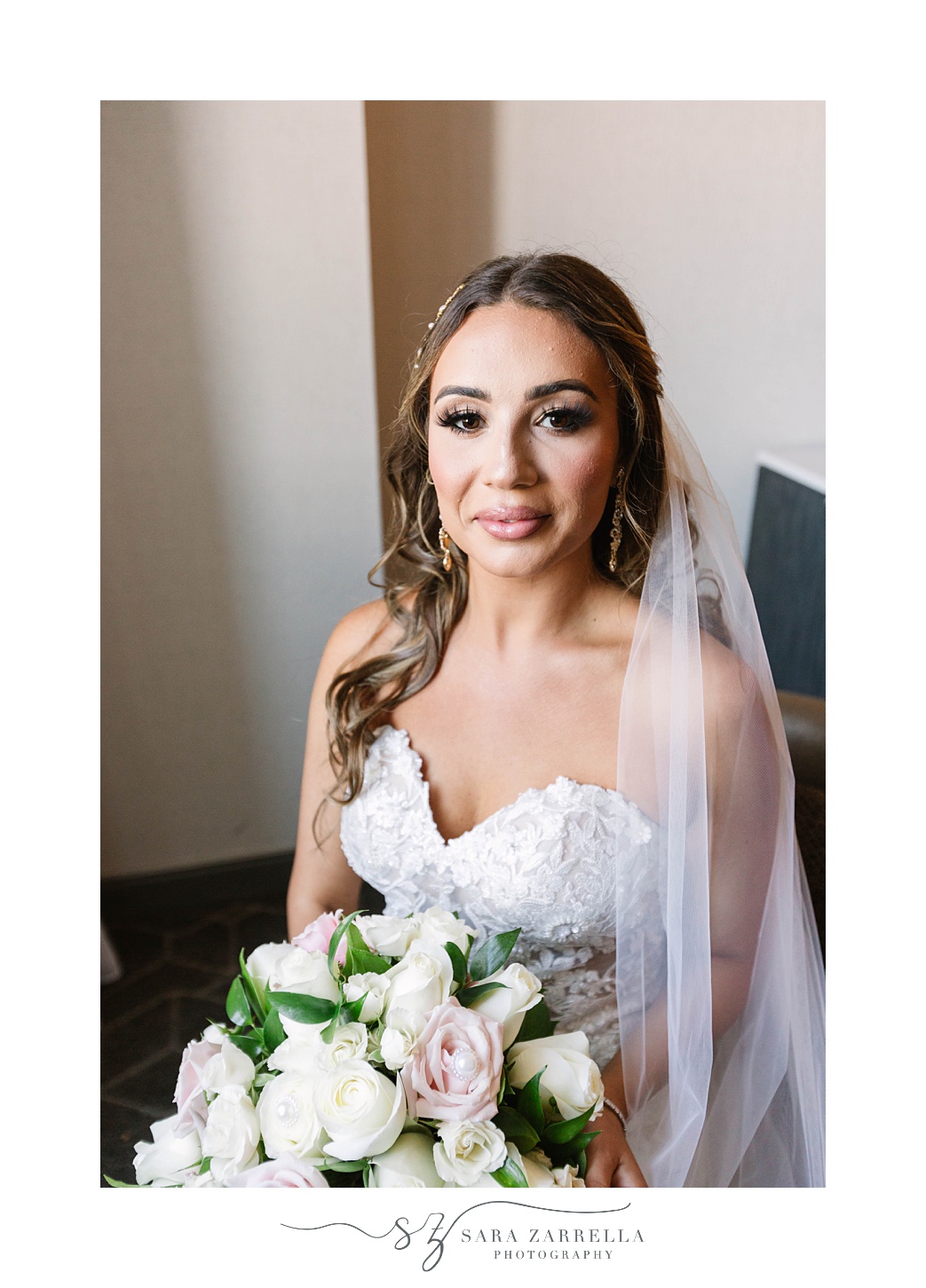 bride sits holding bouquet of white flowers