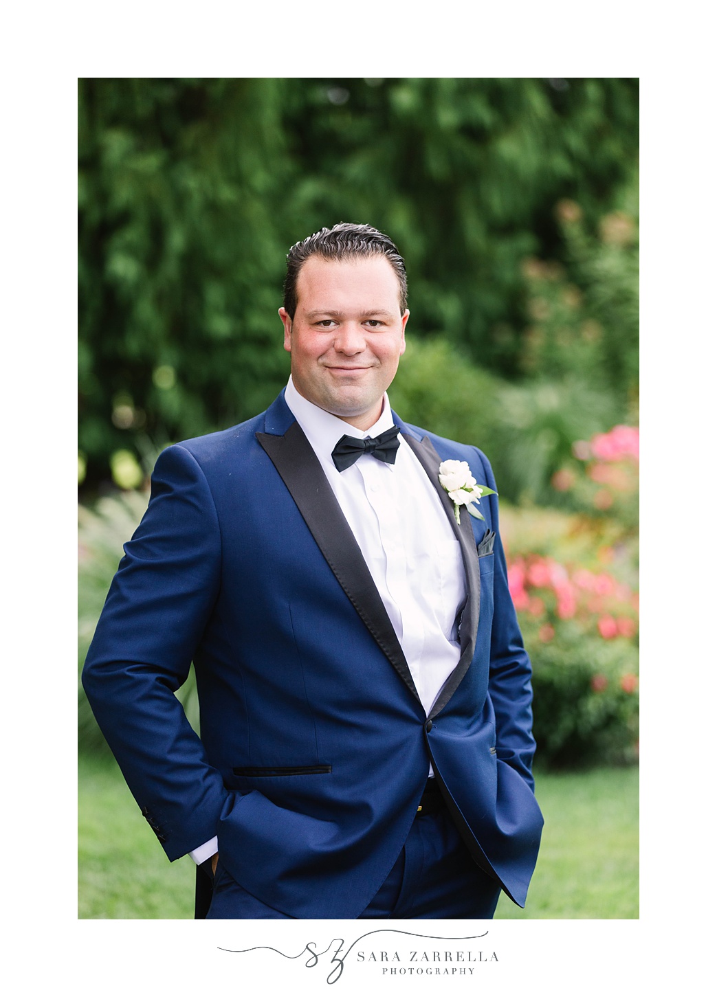 groom poses in navy blue tux