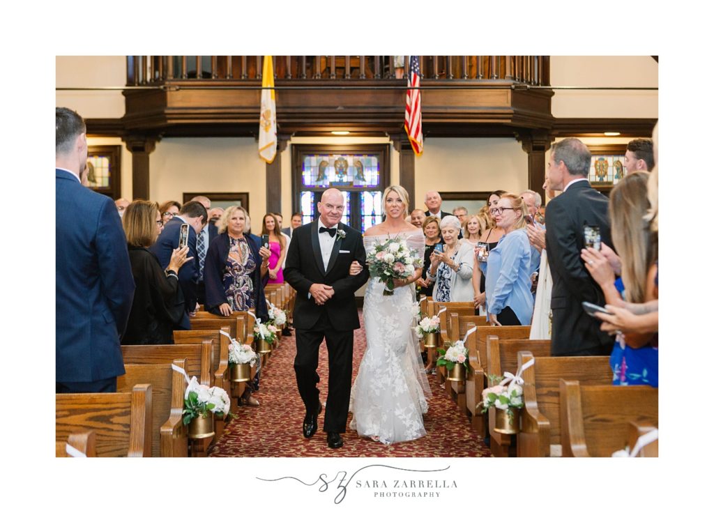 bride and father walk down the aisle for traditional wedding ceremony in Rhode Island
