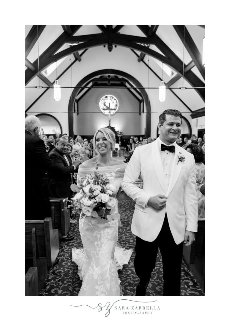 newlyweds walk up aisle after traditional wedding ceremony in Rhode Island