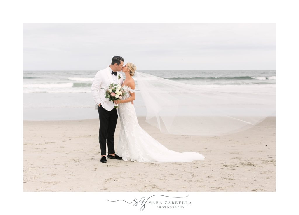 bride and groom kiss along water at Narragansett Bay