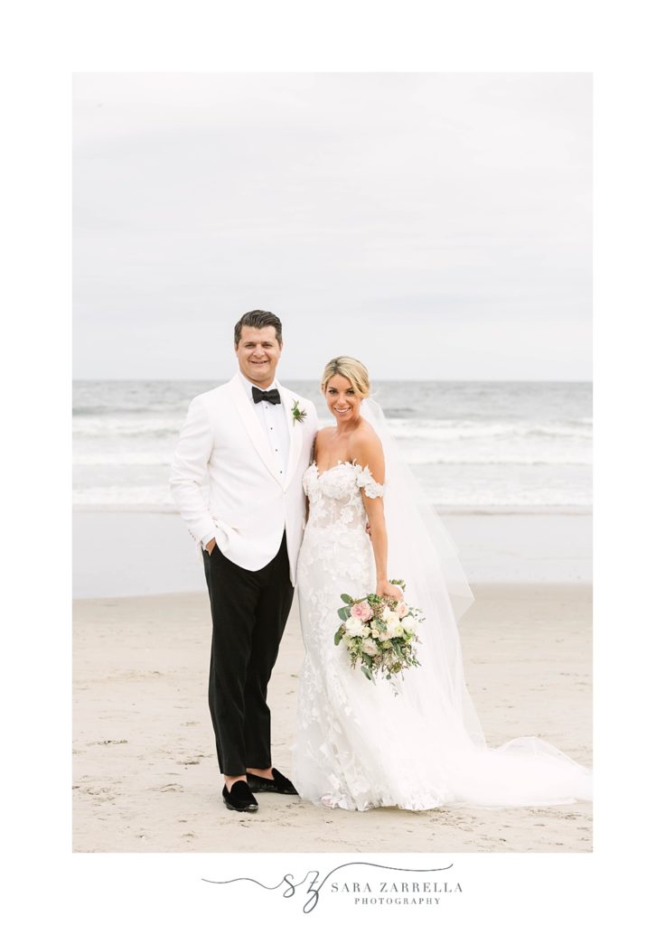 newlyweds smile toeter along beach outside The Dunes Club