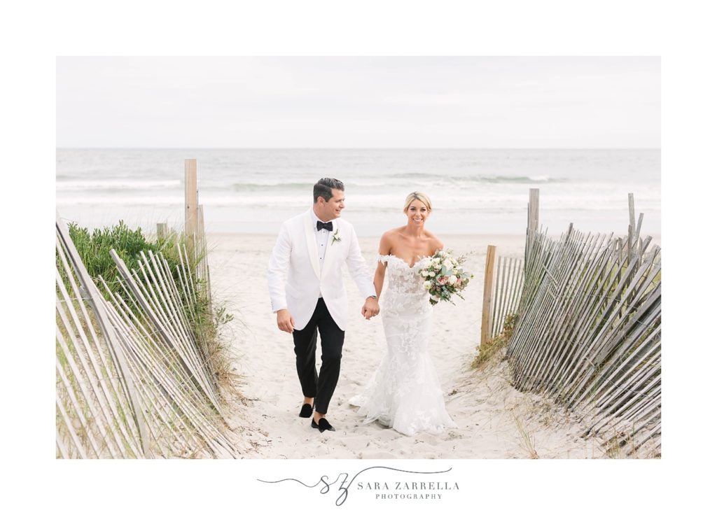 bride and groom walk on beach at Narragansett Bay