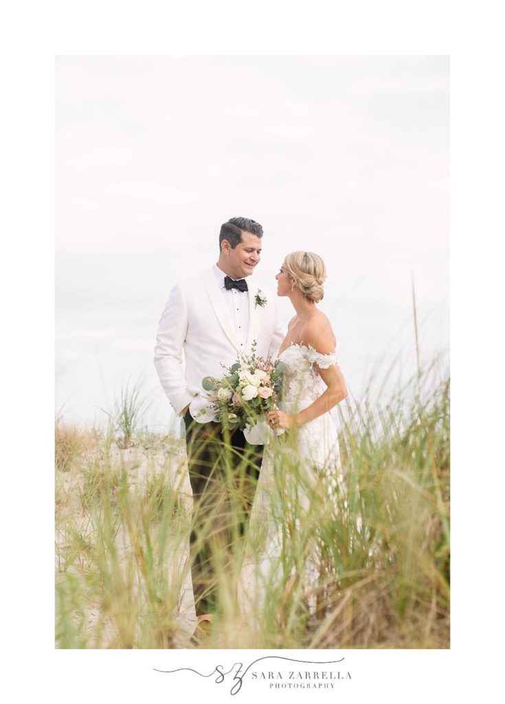 bride and groom kiss in the tall grass at Narragansett Bay