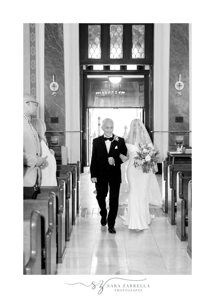 bride and dad walk down aisle for Catholic wedding