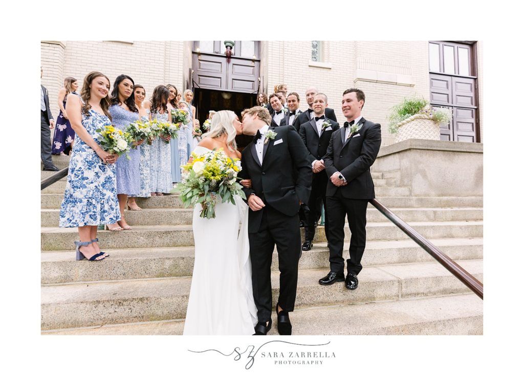 newlyweds kiss on steps of chapel at Salve Regina