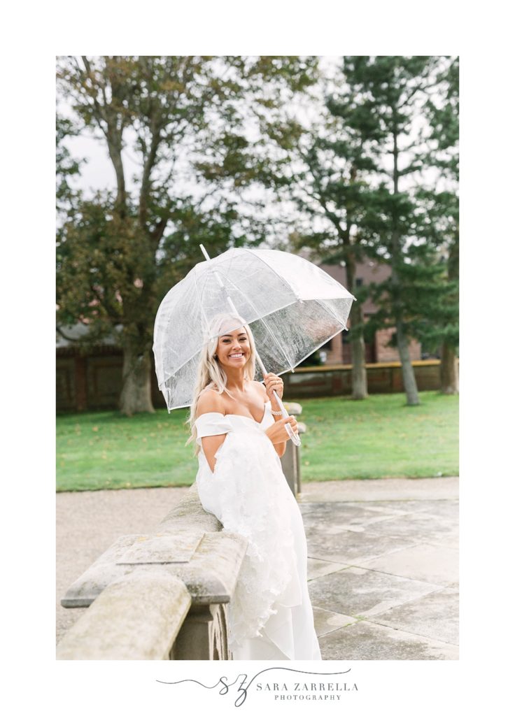 bride holds clear umbrella in the rain during portraits at Ochre Court