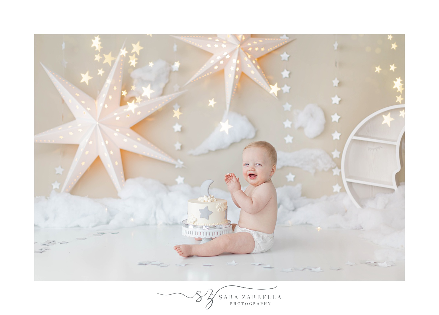 baby in diaper plays during cake smash with Sara Zarrella Photography