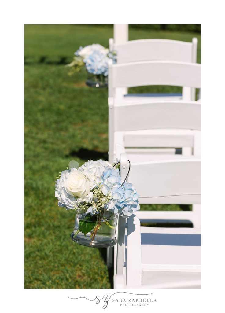 white and blue bouquets hang on white chairs for Spring House Hotel wedding ceremony