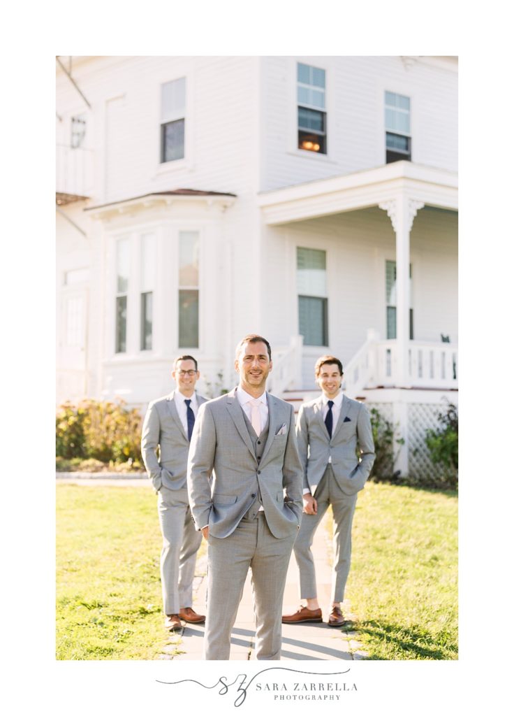 groom poses with groomsmen in grey suits outside the Spring House Hotel