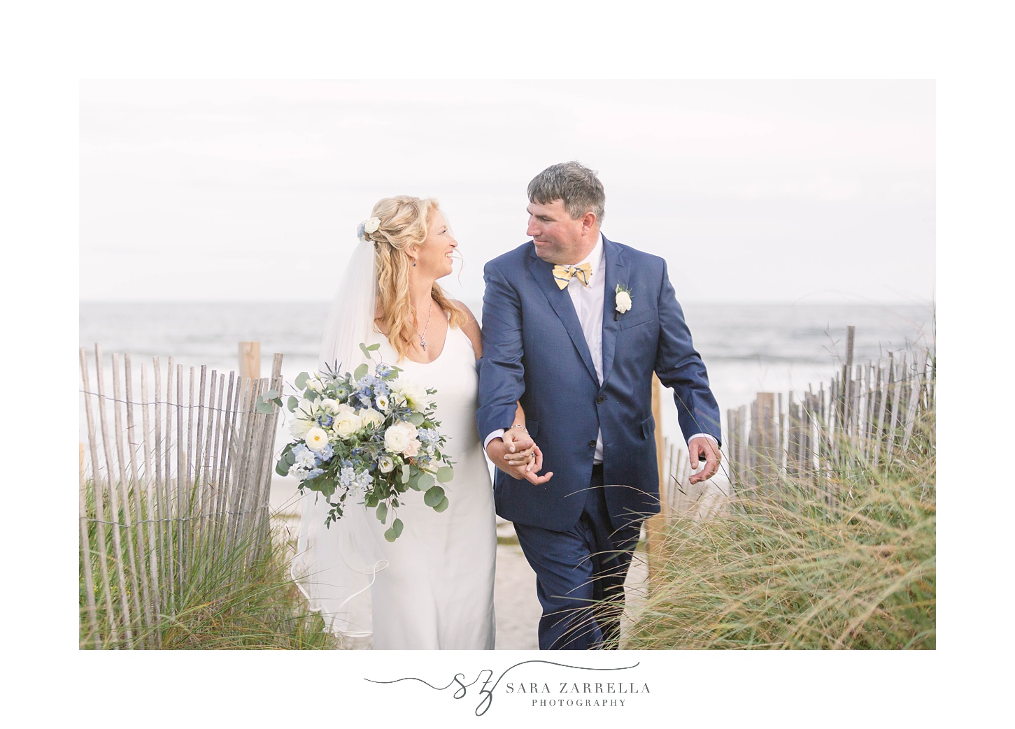 bride and groom hold hands walk through high grass at The Dunes Club