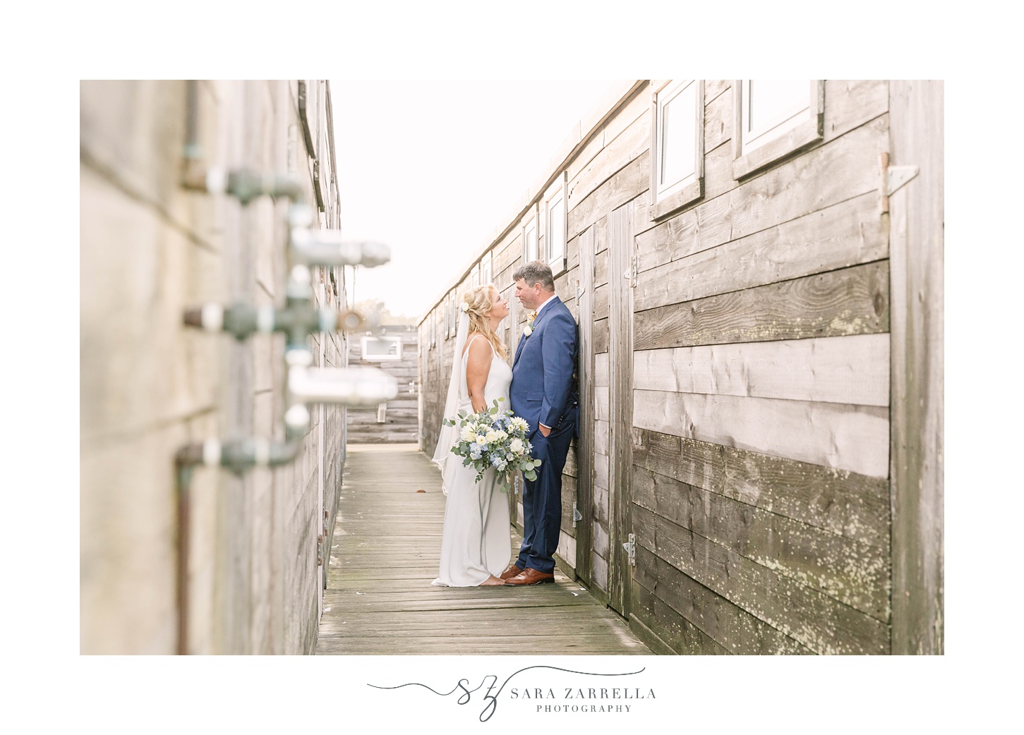 bride and groom pose along wooden walls at The Dunes Club