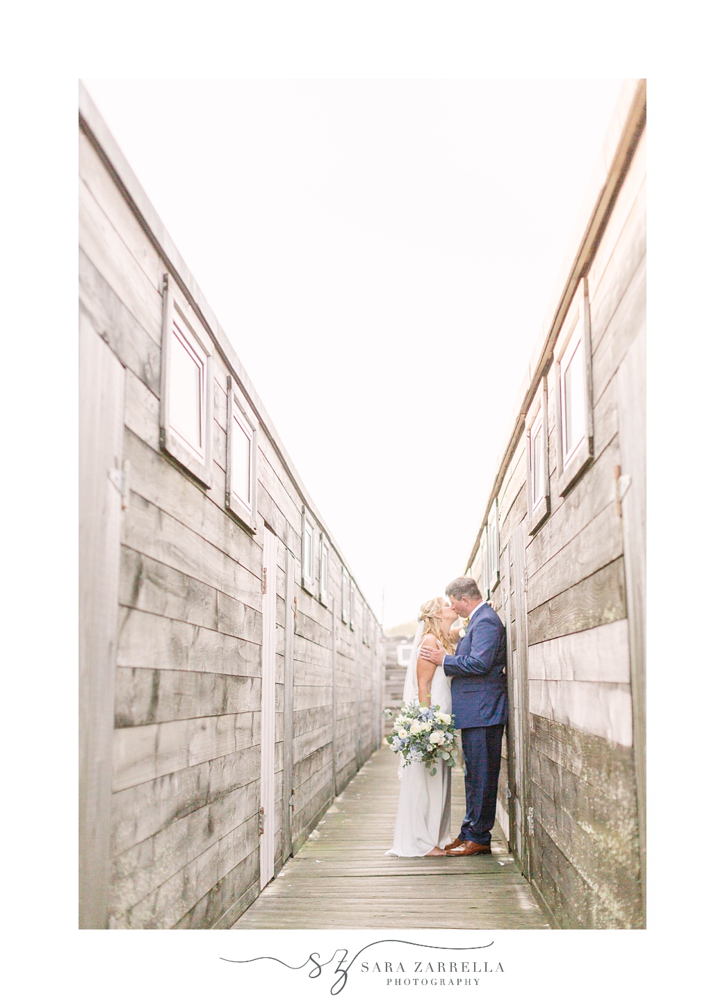 bride and groom pose between wooden walls at The Dunes Club