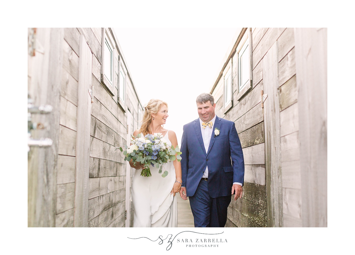 bride and groom hold hands walking through wooden walls at The Dunes Club