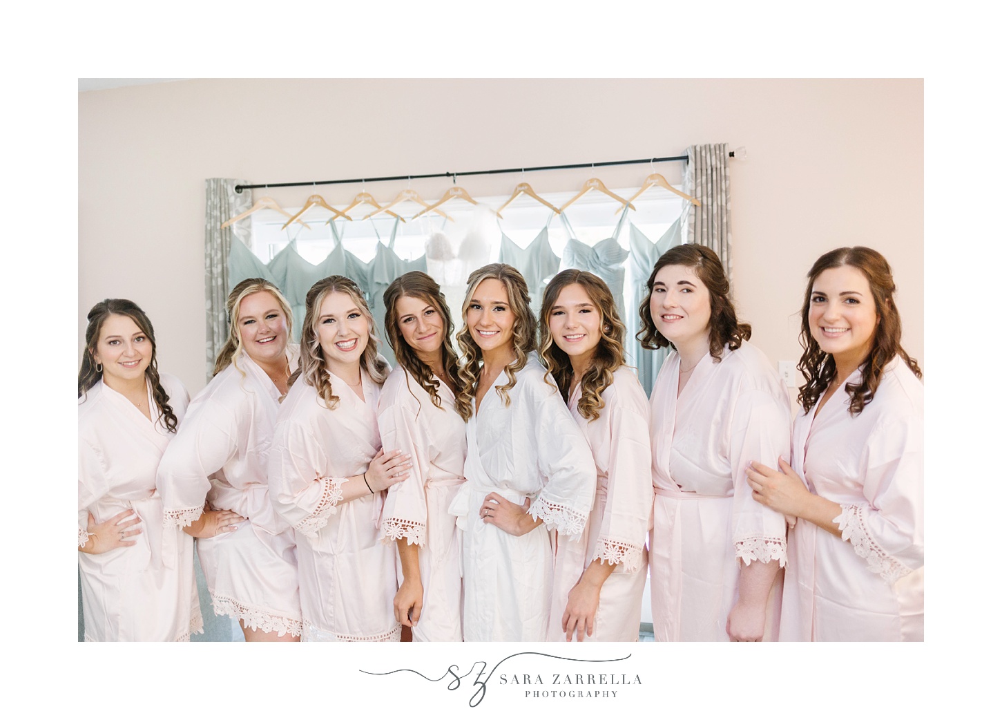 bride and bridesmaids poses in matching pink robes