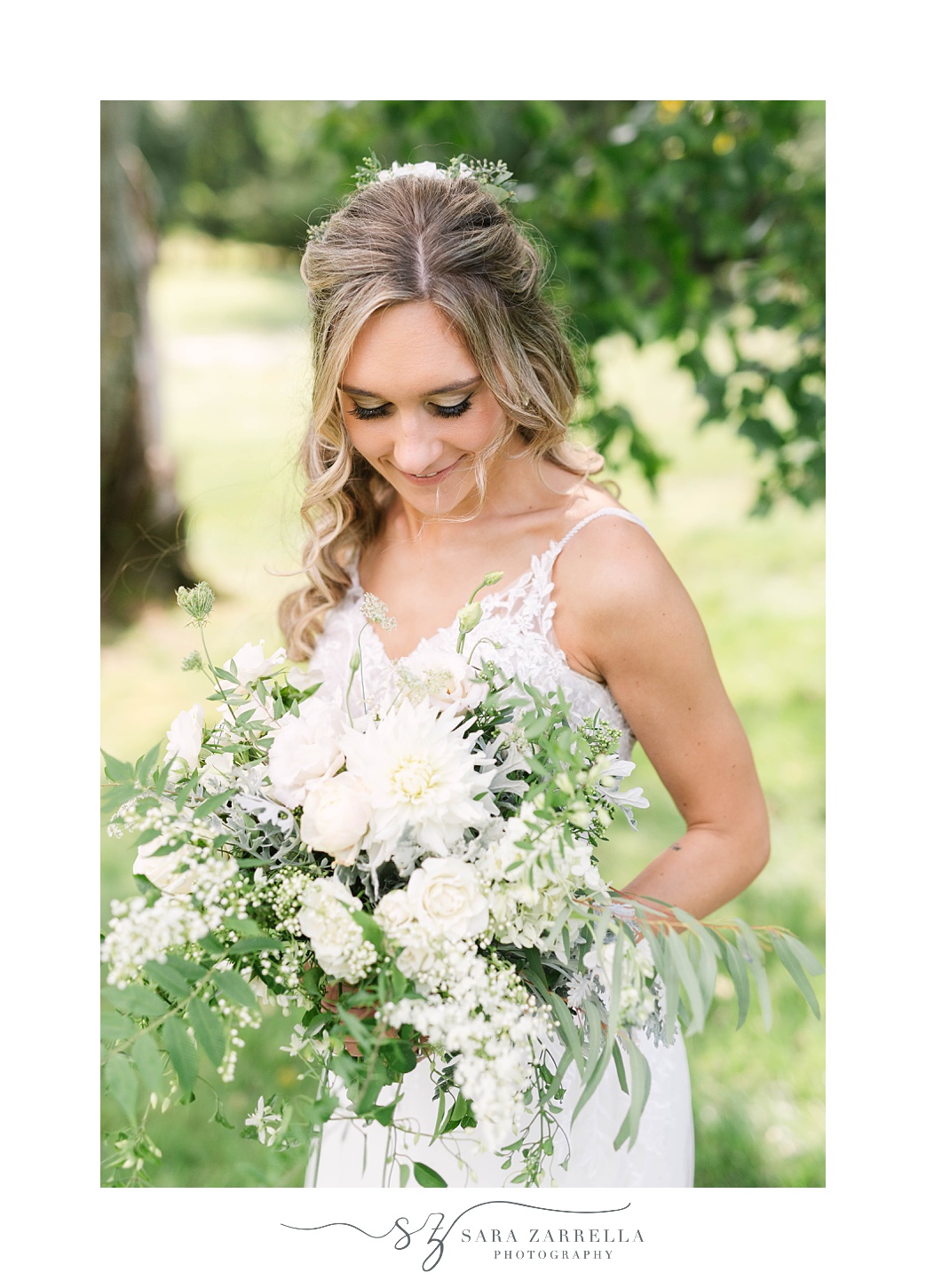 bride looks down at all white bouquet
