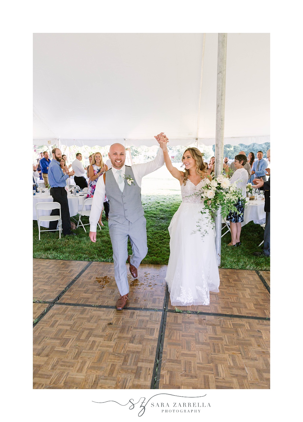 couple holds hands cheering onto dance floor