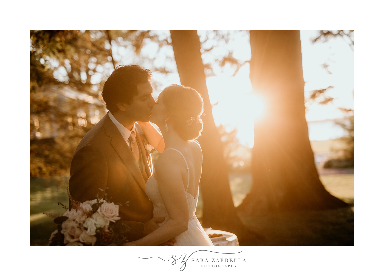bride and groom kiss at sunset by trees