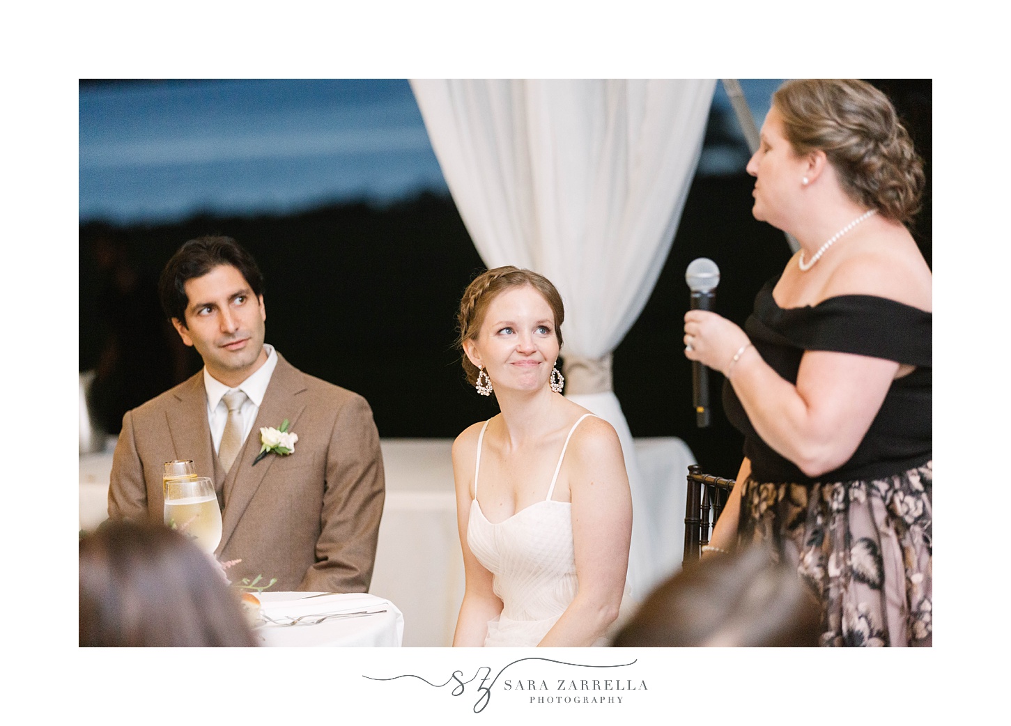 bride smiles at maid of honor during speeches